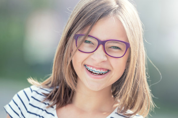 Young girl with braces smiling at Sierra Kids Dentistry in Reno, NV